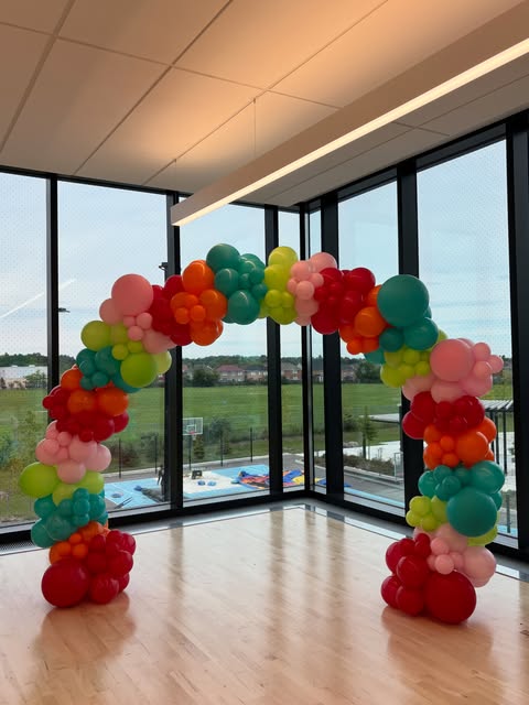 Bright multicolour organic balloon arch in a light-filled venue