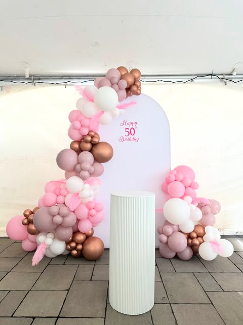 Blush, white, and bronze balloon installation for a birthday celebration