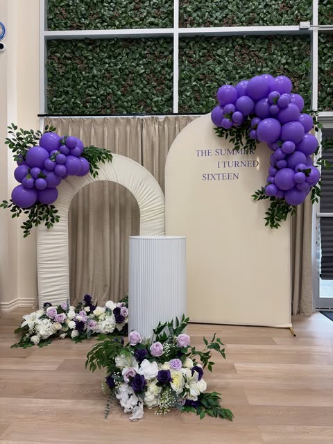 Purple balloon garlands with cream backdrops and floral arrangements